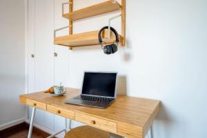 a laptop computer sitting on a wooden desk at Comfortable flat - Montparnasse in Paris