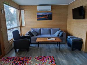 uma sala de estar com um sofá e uma mesa em Heinolan Heinäsaari - Holiday and Camping em Heinola