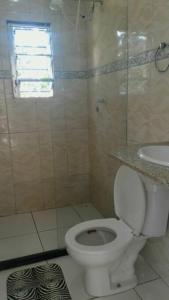 een badkamer met een toilet en een wastafel bij MARAVILHOSA CASA EM BÚZIOS AO LADO DO CENTRO in Búzios