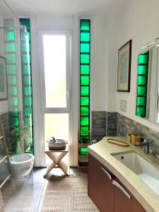 a bathroom with a sink and a shower with green lights at Elizaveta in Oggebbio