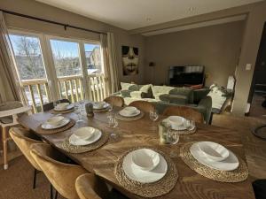 une grande table en bois avec des chaises et un salon dans l'établissement Le Ruisseau - Appartement 8P, à Theux