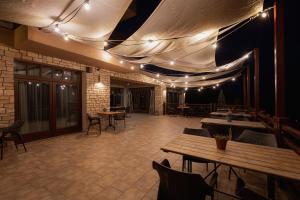 a restaurant with tables and chairs and lights on the ceiling at Hotel Green in Dolný Kubín