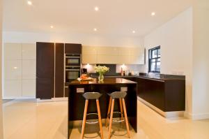 a kitchen with a island with two bar stools at 'Seafarers' Bellevue, Ryde, Isle of Wight in Ryde
