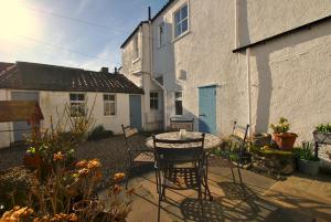 a patio with a table and chairs in front of a building at The Old Surgery Crail- welcoming apartment in Crail