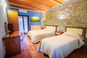een slaapkamer met 2 bedden en een stenen muur bij Green Park Bio Agriturismo in Trentinara
