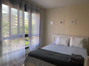 a bedroom with a bed and a large window at Alquilaencanarias El Palm Mar in Palm-Mar