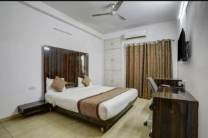 a bedroom with a bed and a desk in a room at Comfort stay Noida sector 19 in Noida