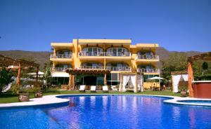 ein Hotel mit einem Schwimmbad vor einem Gebäude in der Unterkunft El Chante Spa Hotel in Jocotepec
