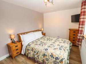 a bedroom with a bed and a dresser and a tv at Cherry Croft in Wigton