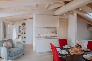 cocina y sala de estar con mesa y sillas rojas en Campolivo, en Gargnano