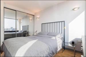a bedroom with a large bed and a large window at Modern 2-bed Apartment 5 mins from London Bridge in London