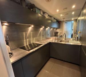 a kitchen with a stainless steel counter and a sink at Modern 2-bed Apartment 5 mins from London Bridge in London