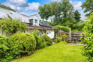 an old house with a garden in front of it at Upper Cottage Newcastle Emlyn in Cwm-pengraig