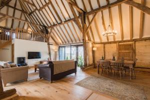 a living room with a table and a dining room at The Thatched Barn in Brabourne