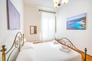 a white bedroom with a bed and a window at Al Bastione in Cagliari