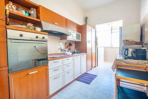 a kitchen with wooden cabinets and white appliances at Al Bastione in Cagliari