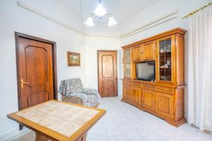 a living room with a tv and a wooden entertainment center at Al Bastione in Cagliari