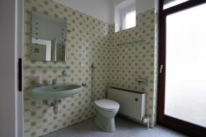 y baño con lavabo, aseo y espejo. en Mieterlux Frankfurt Obertshausen, en Obertshausen