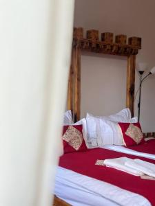 um quarto com uma cama com almofadas vermelhas e brancas em Machanents Art Hotel em Vagharshapat