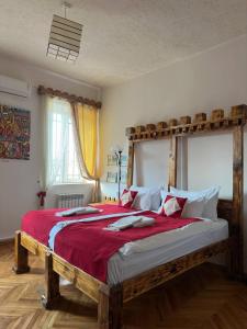 a bedroom with a large wooden bed with red sheets at Machanents Art Hotel in Vagharshapat