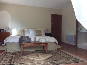 een slaapkamer met een bed en een houten tafel bij La Suite, Les Hautes Roches in Collobrières