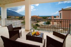 a balcony with chairs and a table with fruit on it at Villa Nikos in Karavadhos