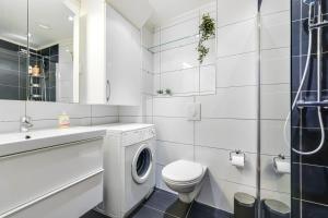 a bathroom with a washing machine and a toilet at Charming and cozy - Centrally located in Oslo