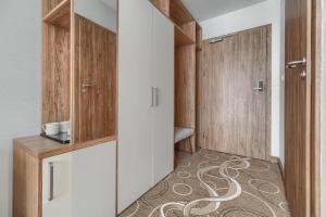 a dressing room with wooden cabinets and a carpet at Platino Mare Resort & Spa in Świnoujście