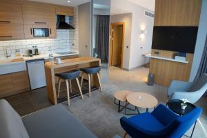cocina abierta y sala de estar con sillas azules en Holiday Inn Express - Ankara - Airport, an IHG Hotel, en Ankara