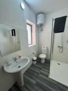 uma casa de banho com um lavatório, um WC e um chuveiro em The Triton em St Paul's Bay