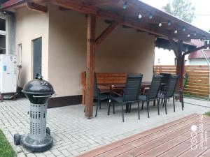 un patio con mesa y sillas bajo toldo en Ubytování BRLOH Sedloňov v Orlických horách, en Sedloňov