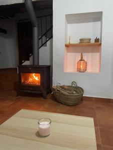 a living room with a fireplace and a table with a candle at La Rosita alojamiento rural in Hinojares +31 photos