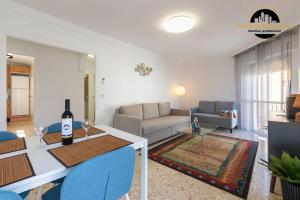 a living room with a couch and a table with a bottle of wine at Apartamento Las Redes Estepona in Estepona