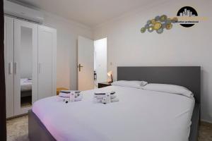 a bedroom with a large white bed with two boxes on it at Apartamento Las Redes Estepona in Estepona
