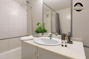 a white bathroom with a sink and a mirror at Apartamento Las Redes Estepona in Estepona +21 photos