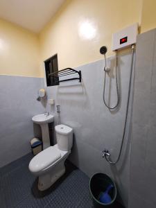 ein Bad mit einem WC und einer Dusche in der Unterkunft Basilia Guest House in Bantayan
