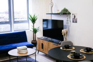 Impeccable 2-Bed Luxury Apartment in Berkshire في براكنيل: غرفة معيشة مع أريكة زرقاء وتلفزيون
