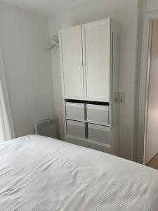 sypialnia z białym łóżkiem i szafką w obiekcie Nussknackerhaus w mieście Sankt Kanzian