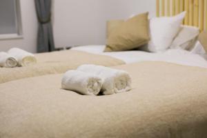 ブラックネルにあるImpeccable 2-Bed Luxury Apartment in Berkshireのベッドの上に座るタオルの山