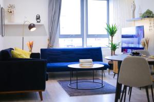 Impeccable 2-Bed Luxury Apartment in Berkshire في براكنيل: غرفة معيشة مع أريكة زرقاء وطاولة