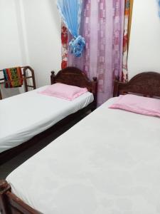 two beds sitting next to each other in a room at Pearl Rest in Mannar