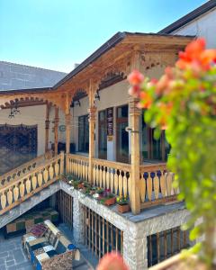a porch of a house with a fence and flowers at Machanents Art Hotel in Vagharshapat