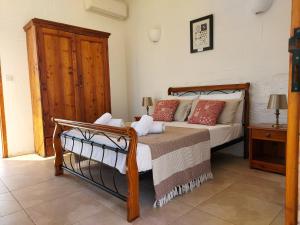 1 dormitorio con 1 cama con cabecero de madera en Razzett Warda B&B, en Għasri