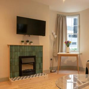 a living room with a fireplace with a tv above it at Stylish Grade II listed house - Pass the Keys in Cheltenham