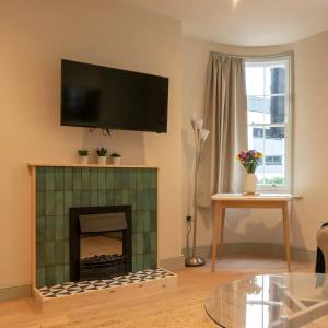 a living room with a fireplace with a tv above it at Pass the Keys Stylish Grade II listed house in Cheltenham