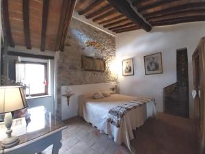 MonterotondoにあるCuore di Toscana Centro Storico Porta alla Torreのベッドルーム1室(ベッド1台、テーブル、窓付)