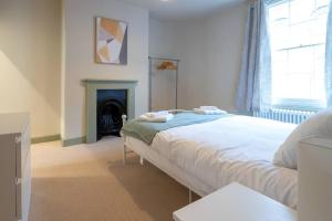 a bedroom with a bed and a fireplace at Stylish Grade II listed house - Pass the Keys in Cheltenham