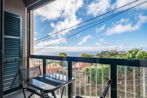 balcón con mesa y sillas y vistas al océano en Canico City Center by Zest and Guest en Santa Cruz