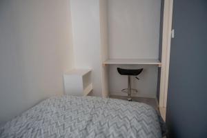 1 dormitorio con cama, escritorio y silla en Panorama view! Modern,Balcony/parking, en Bodø