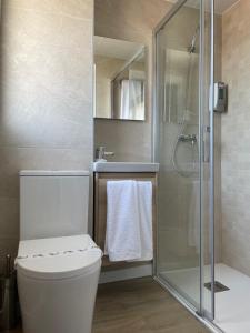 a bathroom with a white toilet and a shower at Hostal Márquez in Yeste